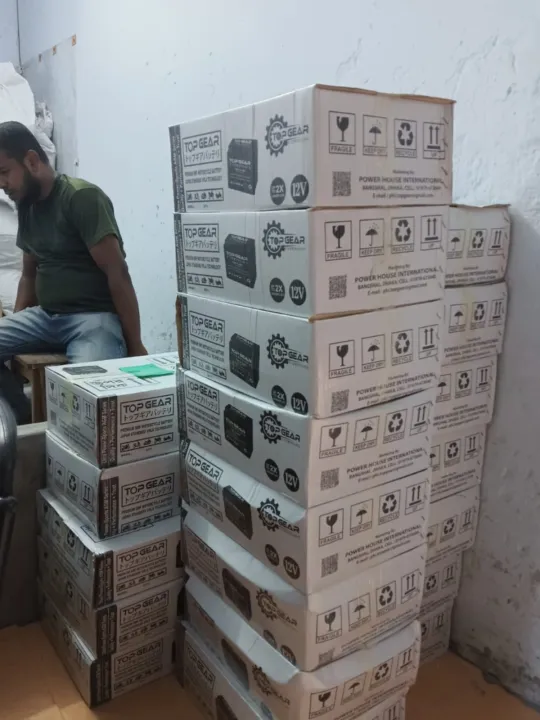 A staff member handling TOP GEAR Battery cartons inside the business premises